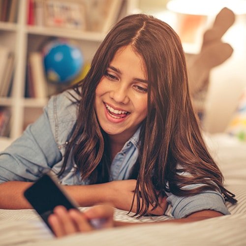 Girl looking at her phone Smile Arc Orthodontics in San Diego, CA